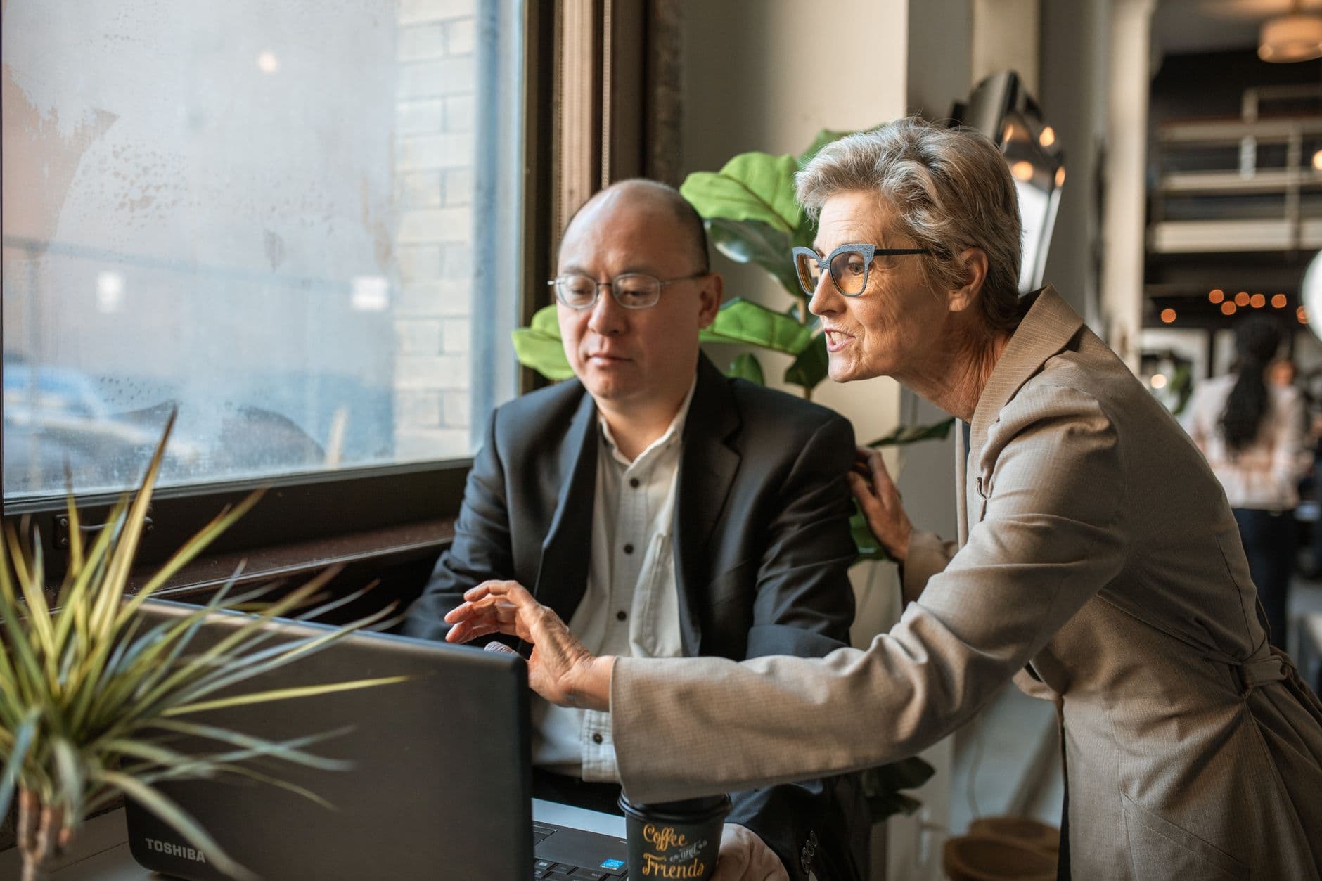A small business owner and a web developer reviewing a website redesign timeline together on a laptop