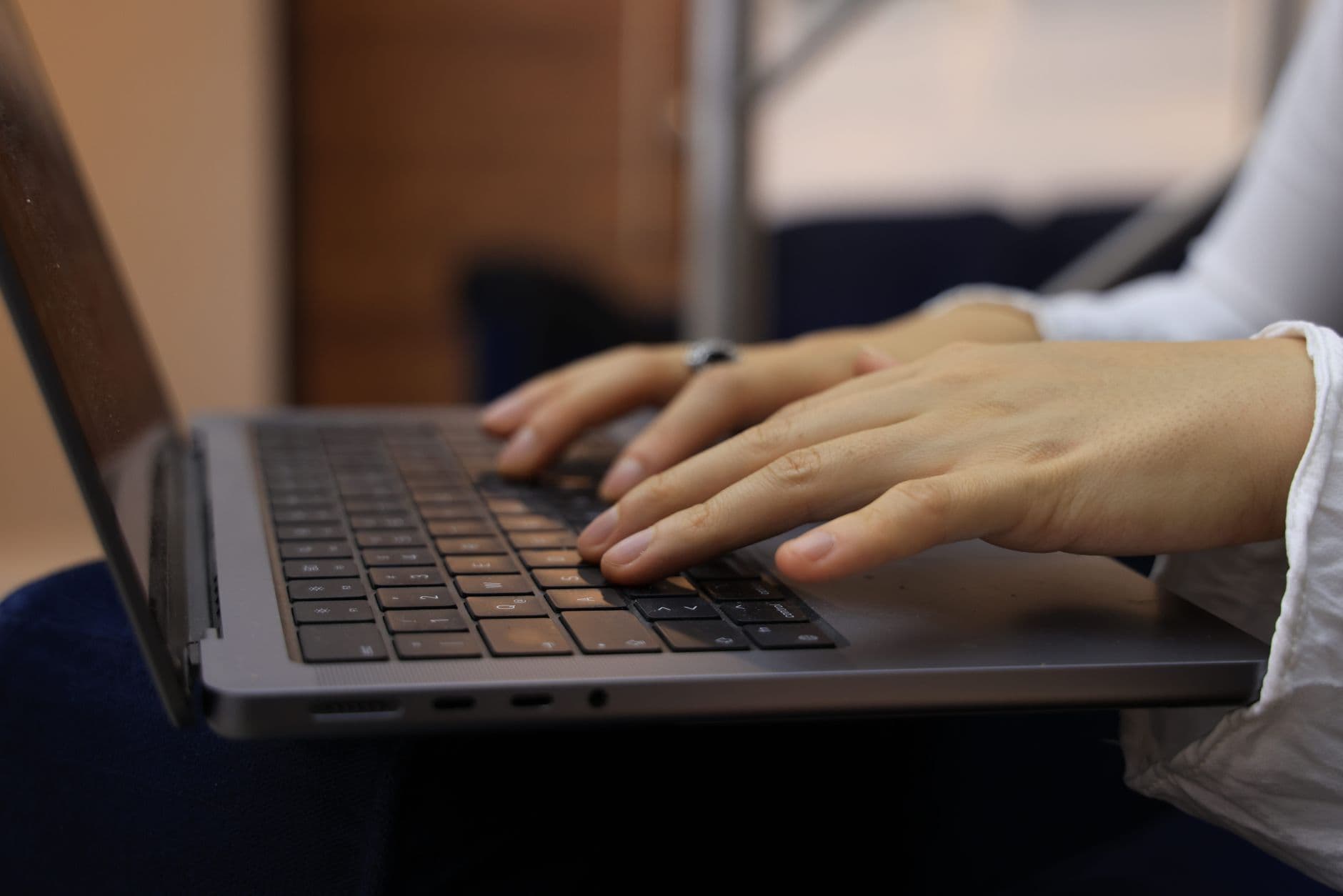 Close-up of hands typing on a laptop keyboard, representing keyboard-based website navigation.