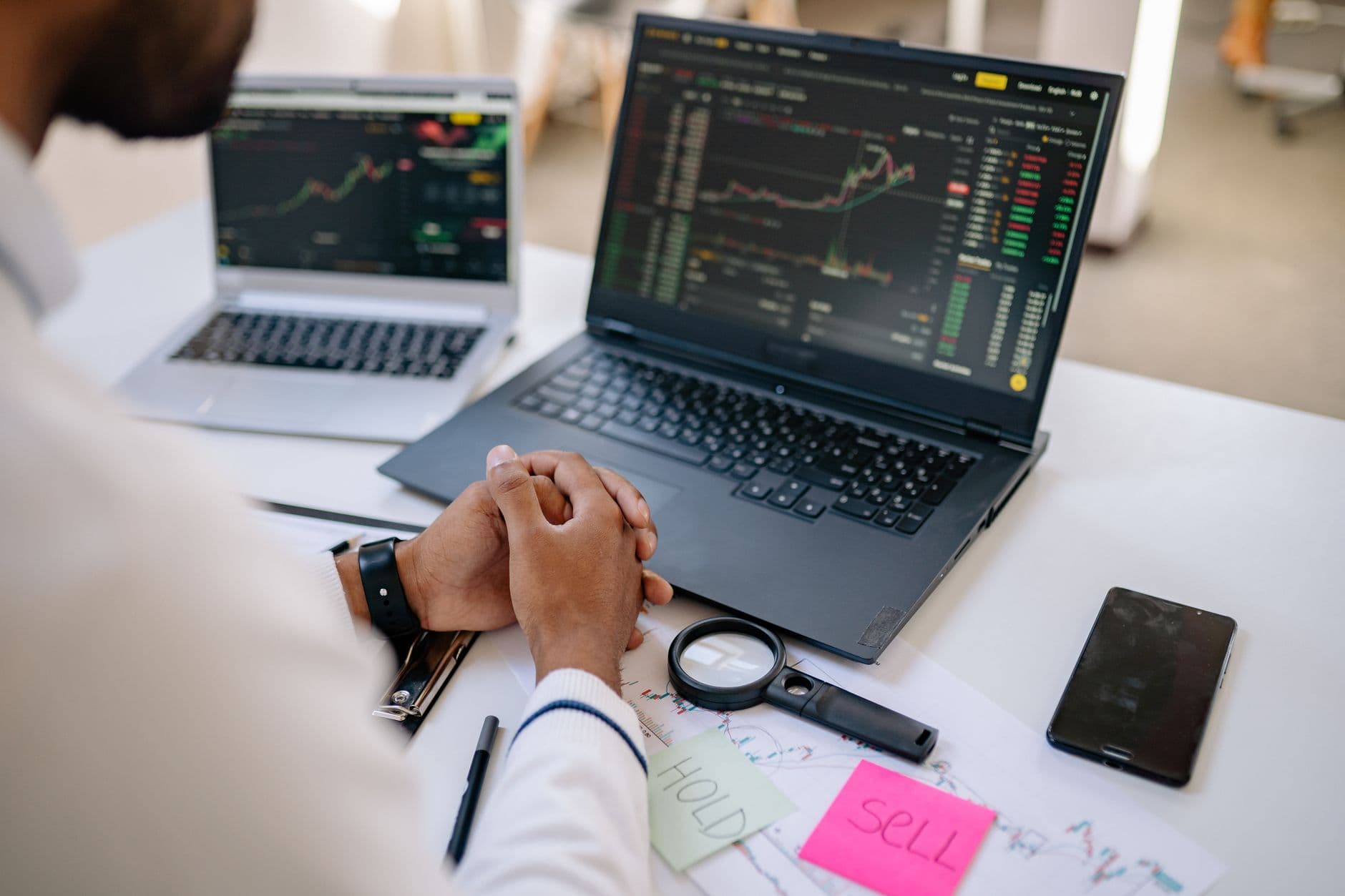 A small business owner weighing options and comparing choices at a desk with a laptop.