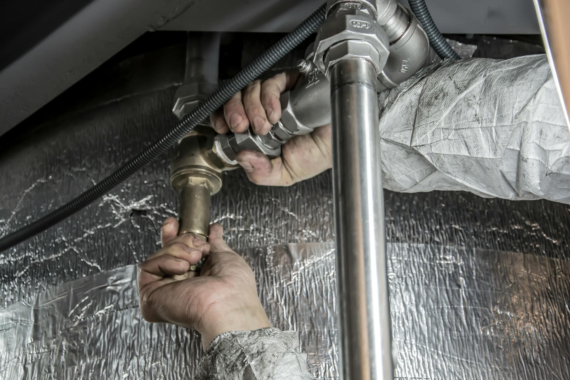 Plumbing SEO services - plumber working on a pipe job, the kind of high-intent search BuzFind helps you win